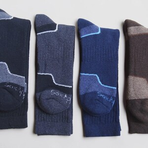 May include: Four pairs of crew socks in navy, charcoal, royal blue, and brown. Each sock features a contrasting color block design on the heel and toe area, with the text "Sox" visible on the toe. The socks have a ribbed texture on the leg.