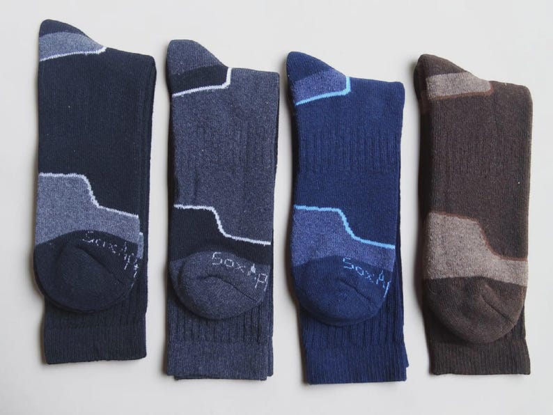 May include: Four pairs of crew socks in navy, charcoal, royal blue, and brown. Each sock features a contrasting color block design on the heel and toe area, with the text "Sox" visible on the toe. The socks have a ribbed texture on the leg.