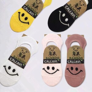 Five pairs of colorful bamboo no show socks with smiley faces in pink, mauve, yellow, white, and black, displayed on a white background.