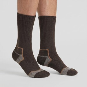 May include: A pair of mid-calf crew socks in a dark brown color. The socks feature a ribbed knit texture along the upper leg section, with contrasting light gray and tan reinforced panels visible at the heel and toe areas of the foot.