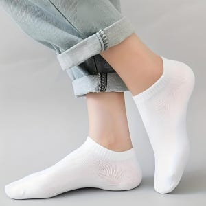 Close-up image of a person's feet wearing white ankle socks and rolled-up jeans, perfect for casual and comfortable fashion.