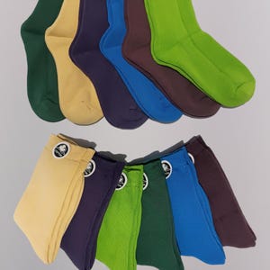 Six pairs of colorful socks displayed overlapping each other, with their cotton tags visible displayed on the bottom half of the screen and there is unfolded versions of the socks at the upper half of screen.