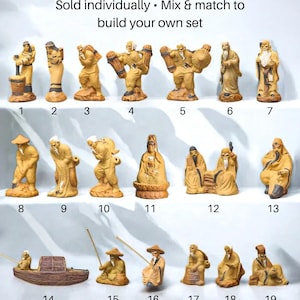 May include: A collection of nineteen tan-colored ceramic Mudman figurines displayed in three rows. Each figure is numbered from 1 to 19 and depicts various poses, including people carrying items, sitting, or fishing. The text CHOOSE YOUR MUDMAN is at the top.