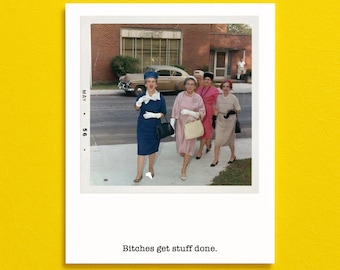 May include: A vintage-style photograph print featuring four individuals walking outdoors in mid-century attire, including dresses, hats, and gloves. The image includes a date stamp of May 56 on the left and the text Bitches get stuff done. below.