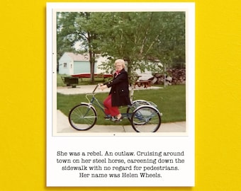 May include: Vintage photograph of a woman riding a blue tricycle on a sidewalk. She wears a black coat and red pants. The image includes text: "She was a rebel. Her name was Helen Wheels."