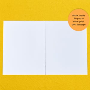 May include: A white greeting card, open to reveal a blank interior, sits against a yellow background. An orange circle in the upper right corner contains the text: "Blank inside for you to write your own message."
