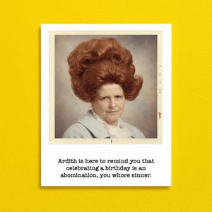 May include: A rectangular greeting card with a white border featuring a vintage-style portrait of a person with voluminous red hair wearing a light blue collared shirt. The text reads: Ardith is here to remind you that celebrating a birthday is an abomination, you whore sinner.