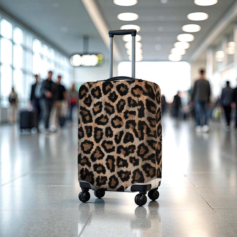 Pode incluir: Uma mala com rodas e al&ccedil;a retr&aacute;til, com um design de estampa de leopardo marrom e preto. A bagagem tem quatro rodas pretas e est&aacute; em um fundo desfocado de aeroporto.