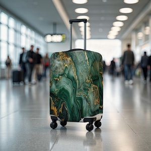 May include: A wheeled suitcase featuring a green and gold marble pattern. It has a retractable handle and four black wheels. The background shows a blurred airport terminal with people walking.
