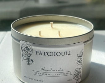 May include: A 16 oz soy wax candle in a round silver metal tin with three wicks. The white label features black text reading PATCHOULI, Handmade, 100% NATURAL SOY WAX CANDLE, WISPY WICK CANDLES, 16 OZ, and illustrations of roses on the sides.