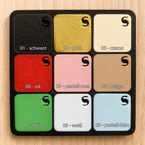 May include: A color palette featuring nine square color swatches in a black grid. Colors include black, gold, cream, red, pastel pink, beige, green, white, and pastel blue. Each swatch is labeled with a number and color name.