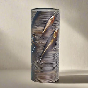 Peut inclure: Conteneur cylindrique avec un motif de grain de bois et des leurres de pêche. Les leurres sont dorés et argentés avec des accents rouges, et sont positionnés pour donner l'impression qu'ils flottent. Le conteneur est de couleur neutre et est debout.