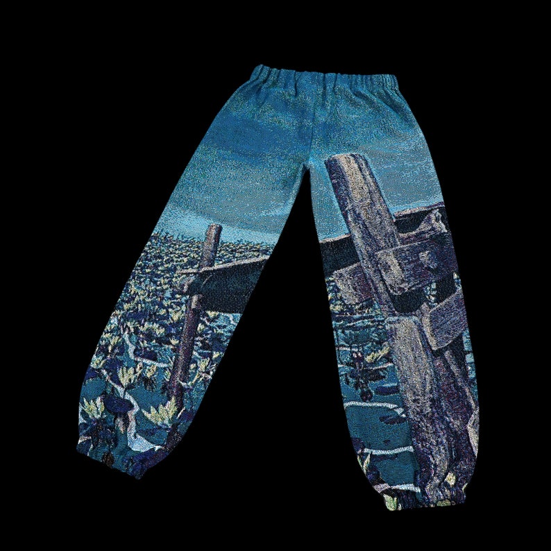 May include: Blue and green patterned pants with a woven design of a fence and a cross.