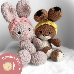 May include: Two crocheted stuffed bunny toys. One is pink with a pink headband and the other is brown with a yellow headband. The bunnies are sitting on a white surface. The text "Crochet Pattern" is visible in the lower left corner of the image.
