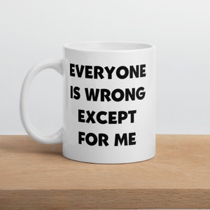 May include: White ceramic coffee mug with black text that reads "Everyone is wrong except for me."