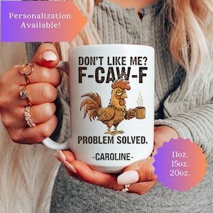 May include: White ceramic mug with a rooster illustration holding a coffee cup. Text on the mug reads "DON'T LIKE ME? F-CAW-F PROBLEM SOLVED." and "-CAROLINE-". Available in 11oz, 15oz, and 20oz sizes. Personalization available.