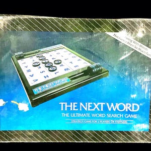 May include: A vintage board game box for "The Next Word," a word search game. The box features a blue and black design with the game board visible. The game board has letters and circular game pieces. The text on the box reads "The Next Word: The Ultimate Word Search Game."