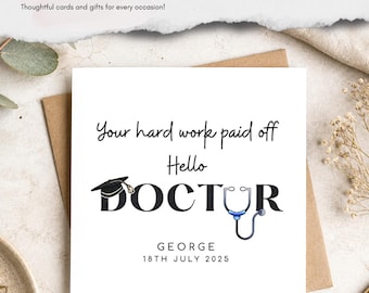 Könnte beinhalten: Eine quadratische weiße Grußkarte mit dem schwarzen Text Your hard work paid off Hello DOCTOR, einem schwarzen Doktorhut-Symbol über dem Buchstaben O und einem blau-silbernen Stethoskop-Symbol anstelle des Buchstabens C. Der Name GEORGE und das Datum 18TH JULY 2025 stehen darunter.