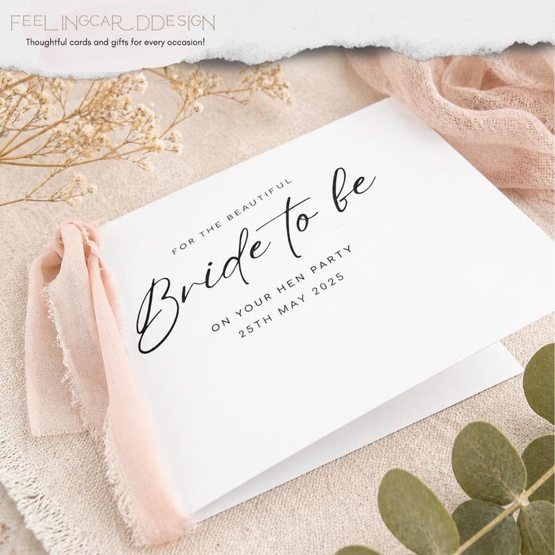 May include: A white folded greeting card featuring black text that reads FOR THE BEAUTIFUL Bride to be ON YOUR HEN PARTY 25TH MAY 2025. The card is adorned with a soft, light pink frayed fabric ribbon attached to the left side of the card cover.
