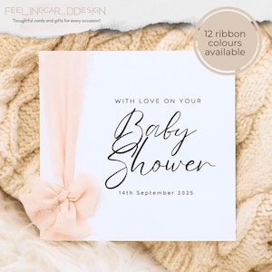 May include: A square white card featuring the black text WITH LOVE ON YOUR Baby Shower and 14th September 2025. A soft peach-colored frayed ribbon is tied in a bow on the left side of the card. A circular badge in the top right corner states 12 ribbon colours available.