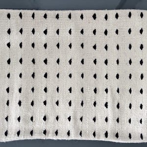 Studio CM | A cream colored wool pillowcase that has black dots made in Oaxaca Mexico by hand