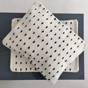 Studio CM | A cream colored wool pillowcase that has black dots made in Oaxaca Mexico by hand