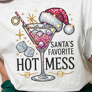 Może przedstawiać: Szary T-shirt z błyszczącym wzorem kieliszka do martini i tekstem "Santa's Favorite Hot Mess".