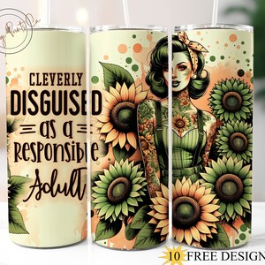 May include: A stainless steel tumbler with a straw, featuring a design of a woman surrounded by sunflowers. The tumbler has the text "CLEVERLY DISGUISED as a RESPONSIBLE Adult". The design includes green, yellow, and orange colors.