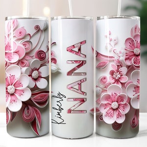 Puede incluir: Tres vasos de acero inoxidable con fondo blanco y diseños de flores de papel rosa. El vaso del medio tiene la palabra "NANA" en letra cursiva y la palabra "Kimberly" debajo.