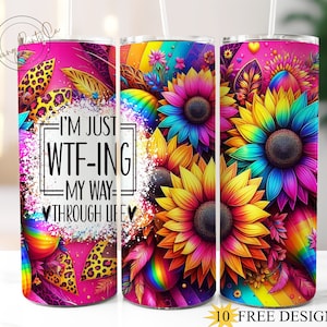 May include: A stainless steel tumbler with a pink background and a rainbow design featuring sunflowers. The tumbler has the text "I'm just WTF-ing my way through life" printed on it.