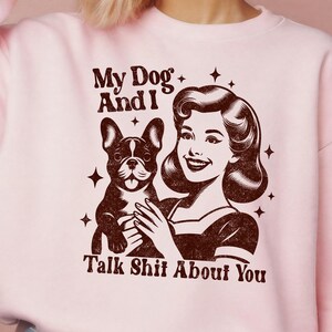 Może przedstawiać: R&oacute;żowa bluza z brązowym nadrukiem przedstawiającym kobietę trzymającą buldoga francuskiego. Tekst na nadruku brzmi "My Dog And I Talk Shit About You."