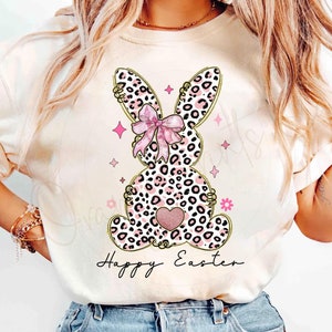 May include: A white t-shirt with a pink and black leopard print bunny with a pink bow and the text "Happy Easter".