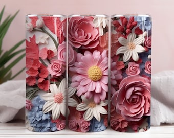 May include: Three stainless steel tumblers featuring a floral design. The tumblers are adorned with pink, white and blue 3D flowers.