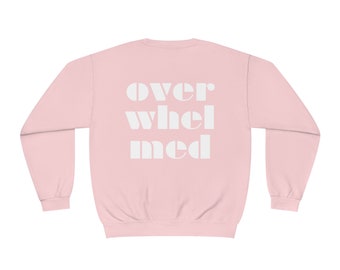 Puede incluir: Sudadera rosa con el texto "over whel med" en blanco.