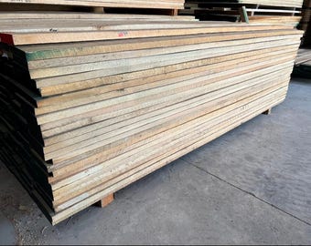 May include: A stack of light brown wooden planks, likely for construction or woodworking projects.