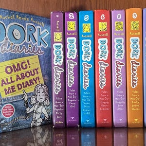 May include: A collection of 10 Dork Diaries books with colorful covers featuring illustrations of girls. The first book is titled "OMG! All About Me Diary!" and the rest are numbered 2, 5, 6, 8, 9, 11, and 14. The books are all by Rachel Renée Russell.