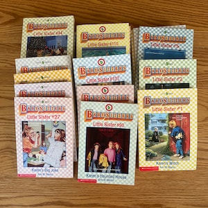 May include: A collection of 10 Baby-Sitters Little Sister books by Ann M. Martin. The books are arranged in two rows of five. The covers feature illustrations of the characters and scenes from the stories. The titles of the books are "Karen's Big Joke", "Karen's Haunted House", "Karen's Witch", "Little Sister #1", "Little Sister #2", "Little Sister #5", "Little Sister #27", "Little Sister #90", "Little Sister #107", and "Little Sister #110".