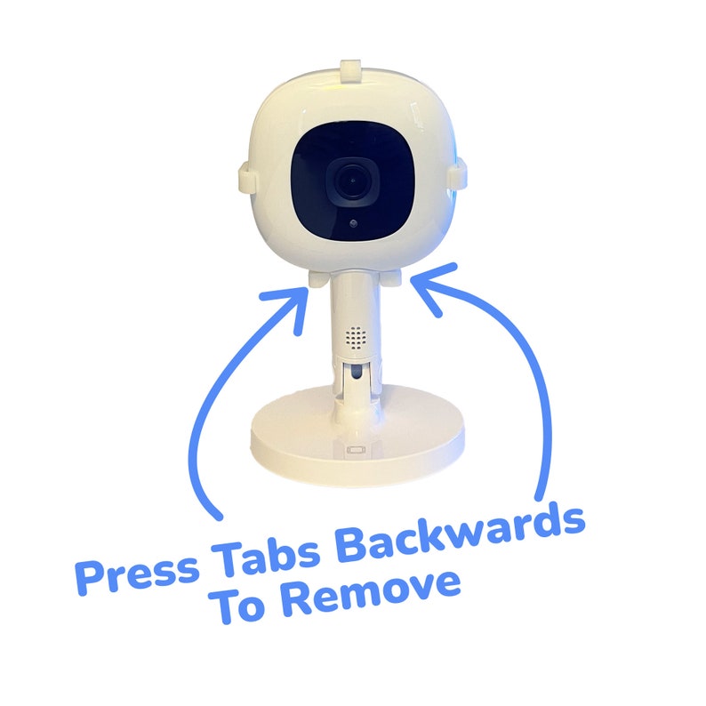 May include: White baby monitor with a round camera lens and a base. The base has two tabs on the sides that can be pressed backwards to remove the camera from the base.
