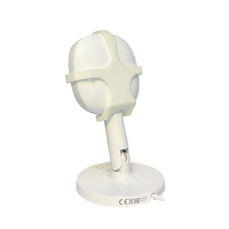 May include: White baby monitor with a white protective cover on the camera lens. The monitor is on a white base with a power cord.