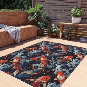 Puede incluir: Una alfombra azul y negra con un patrón repetitivo de peces koi rojos y naranjas nadando en olas. La alfombra está sobre un suelo de madera.