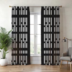 May include: Black and white patterned window curtains. The curtains feature a repeating vertical design of white rectangles against a black background. The curtains are hanging in front of a window, with a plant and chair visible.