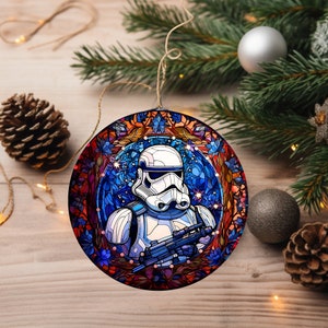 May include: A round Christmas ornament featuring a stained glass design of a Star Wars Stormtrooper in a blue and red floral pattern.