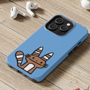 Pode incluir: Uma capa de telefone azul com um gato marrom de desenho animado com listras brancas e barriga branca. A capa tem um recorte para a lente da câmera e uma borda elevada ao redor da tela.