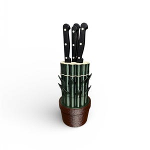 Può includere: Un set di coltelli con quattro coltelli neri con dettagli a pois bianchi. I coltelli sono alloggiati in un supporto in stile bambù, che si trova in un vaso marrone. I coltelli sono disposti verticalmente.