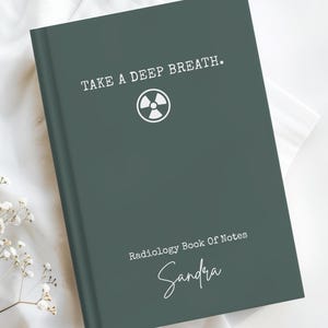 May include: A dark green notebook with white text that reads TAKE A DEEP BREATH. and Radiology Book Of Notes, featuring a white radiation symbol icon and the name Sandra in a white script font centered on the front cover of the book.