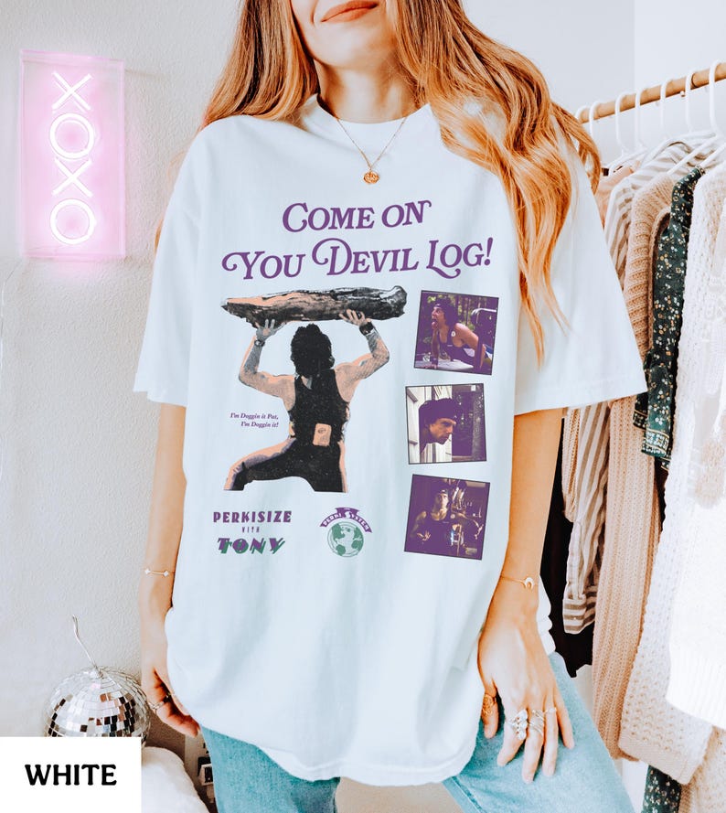May include: White t-shirt with a graphic design featuring the text "Come On You Devil Log!" in purple, along with an illustration of a person holding a log and three smaller images. The shirt also includes the text "Perkisize with Tony".