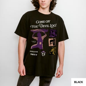 May include: Black t-shirt with the text "Come On You Devil Log!" and a graphic of a person lifting a log. The shirt also features the text "Perkisize with Tony" and several small images. The shirt is black.