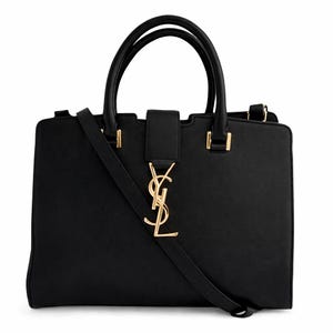 May include: A black handbag with a gold-colored logo and hardware. The bag has two top handles and a detachable shoulder strap. The rectangular bag features a flap closure and a gold logo on the front.
