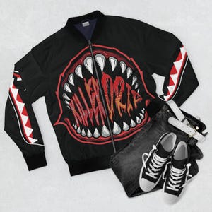 May include: Black bomber jacket with a red and white shark tooth design on the sleeves and a large red and white shark mouth graphic on the back with the text "KILLERCRAZE" inside the mouth.