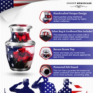 May include: A keepsake urn with a patriotic design. The urn features a silver lid and base, with a body adorned with the American flag and red roses. The text "COGENT MEMORIALS" is at the top.